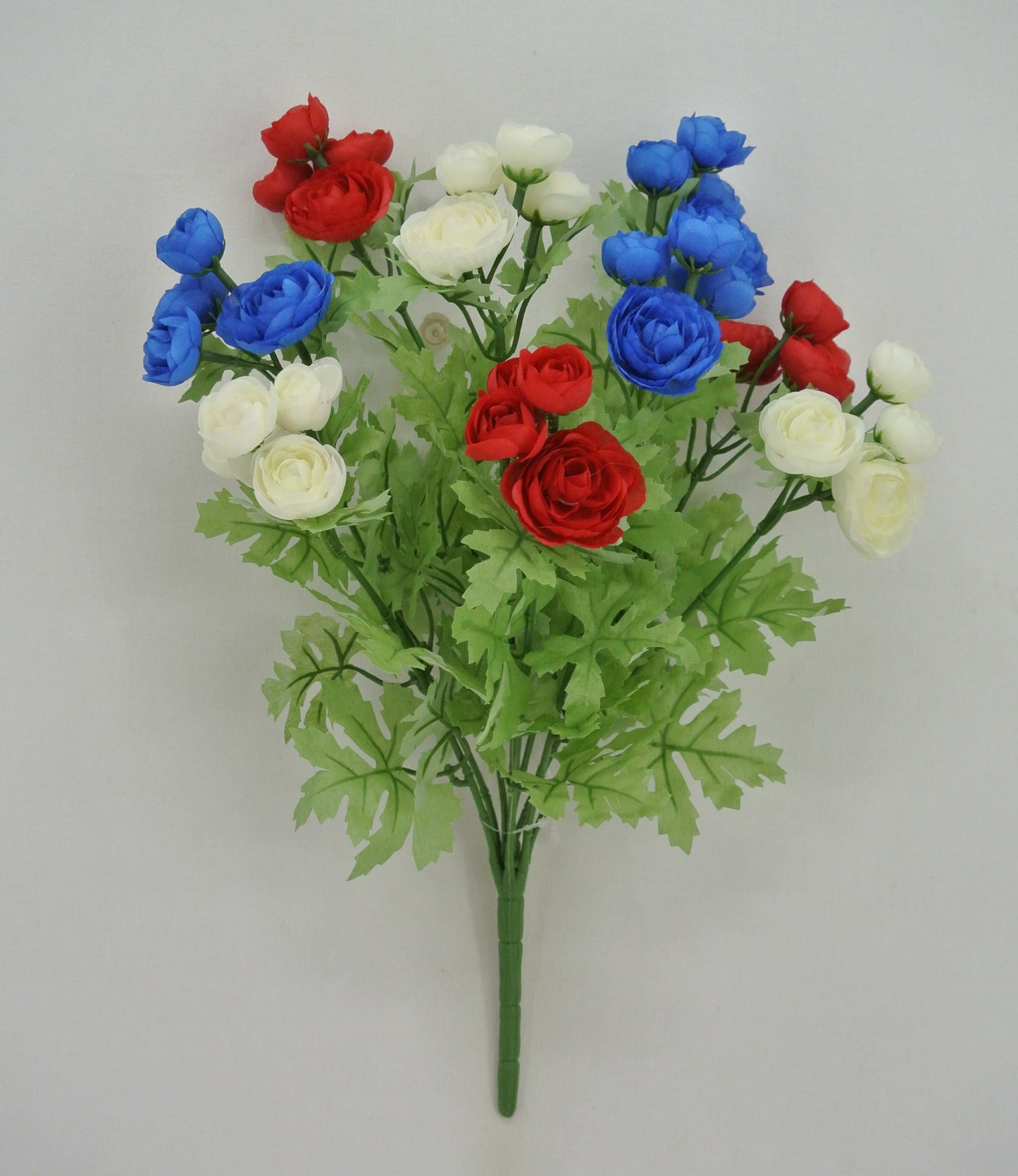 A bouquet of red, white, and blue flowers, including roses and greenery, is displayed against a plain white background.