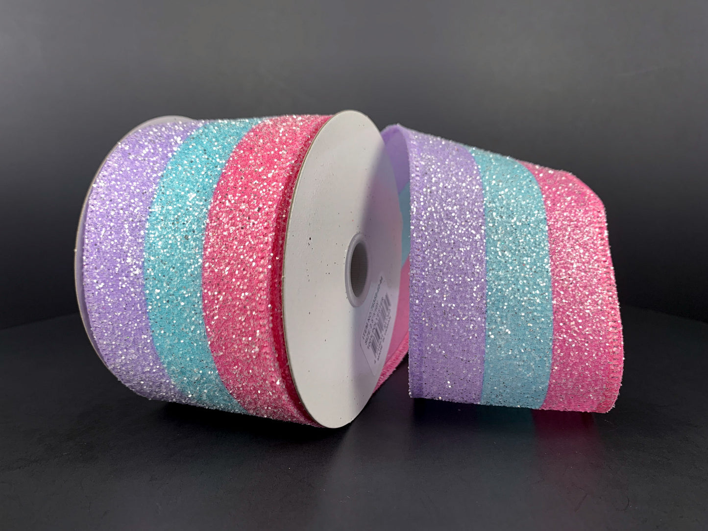 a roll of pink, blue, and purple glitter ribbon