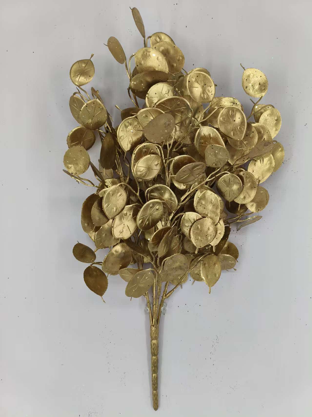 a group of golden, leaf-like objects arranged in a cluster, creating a visually striking and intricate design.