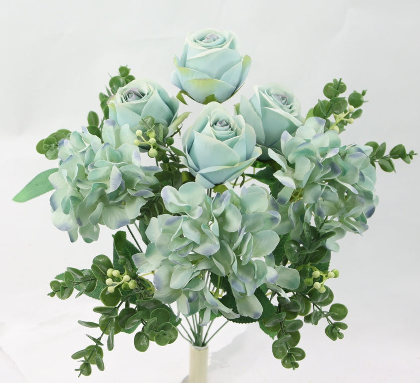 A bouquet of light blue roses and green foliage, including hydrangeas and eucalyptus, arranged in a vase.