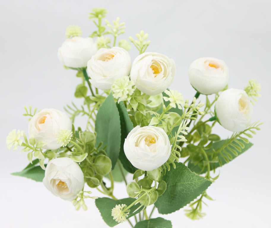 a vase filled with white flowers and green leaves