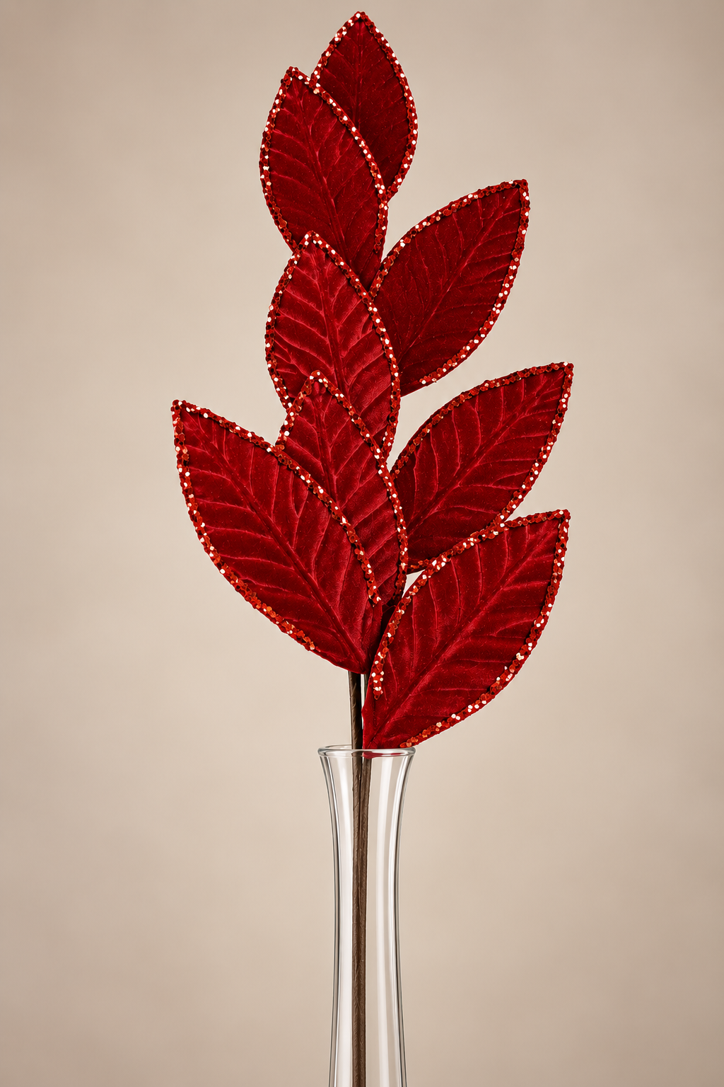 A clear glass vase holding a branch with red leaves, creating a visually appealing and decorative arrangement.
