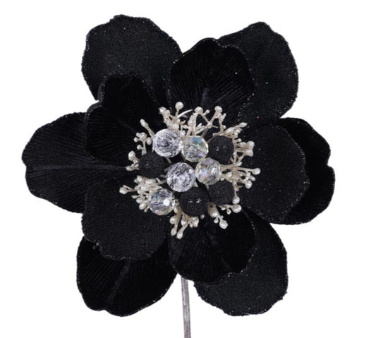 A close-up image of a black flower with a sparkling crystal center.