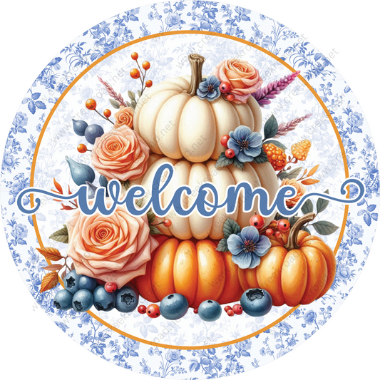 A circular design featuring a white pumpkin surrounded by various fall-themed elements, including orange roses, blue berries, and orange pumpkins. The word "welcome" is written in cursive across the image.