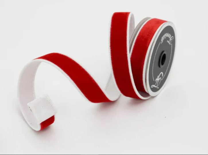 a roll of red and white ribbon on a white background