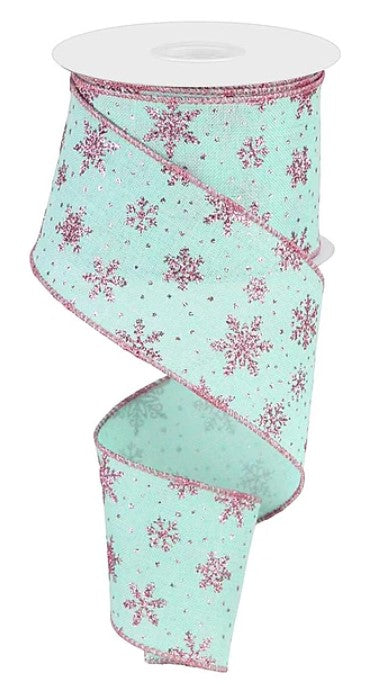 A turquoise and pink snowflake-patterned ribbon is shown, with the ribbon coiled and attached to a white spool.