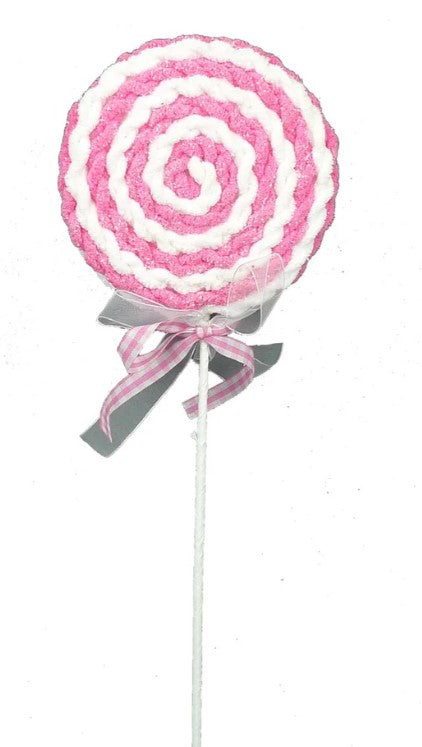 a pink and white lollipop on a stick