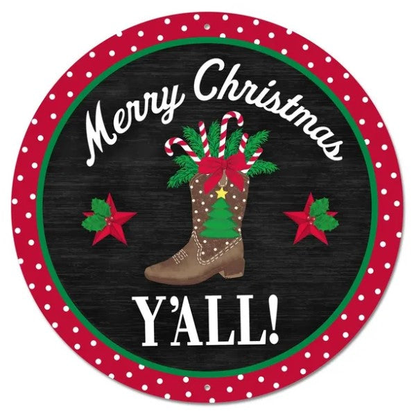 A circular sign with a festive Christmas theme, featuring a cowboy boot, candy canes, holly leaves, and stars. The sign has a red border and the text "Merry Christmas Y'all!" written in white.
