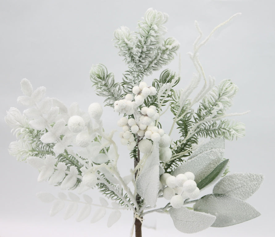 A close-up view of a branch with snow-covered branches and white flowers, creating a serene and wintry atmosphere.