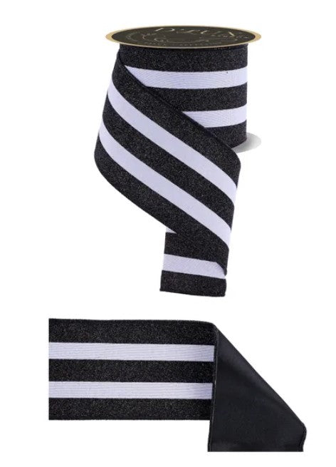 a spool of black and white ribbon with a gold clasp, and a smaller black ribbon with white stripes.