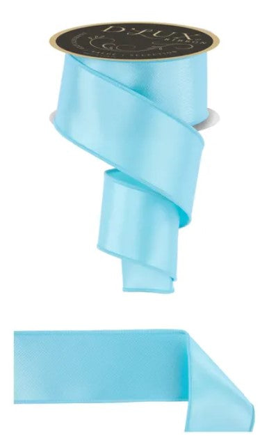 a light blue satin ribbon with a gold label, and a smaller piece of the same ribbon.