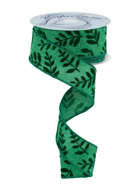 A spool of green ribbon with a leafy pattern printed on it.