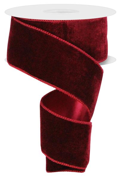 a roll of red velvet ribbon on a white background