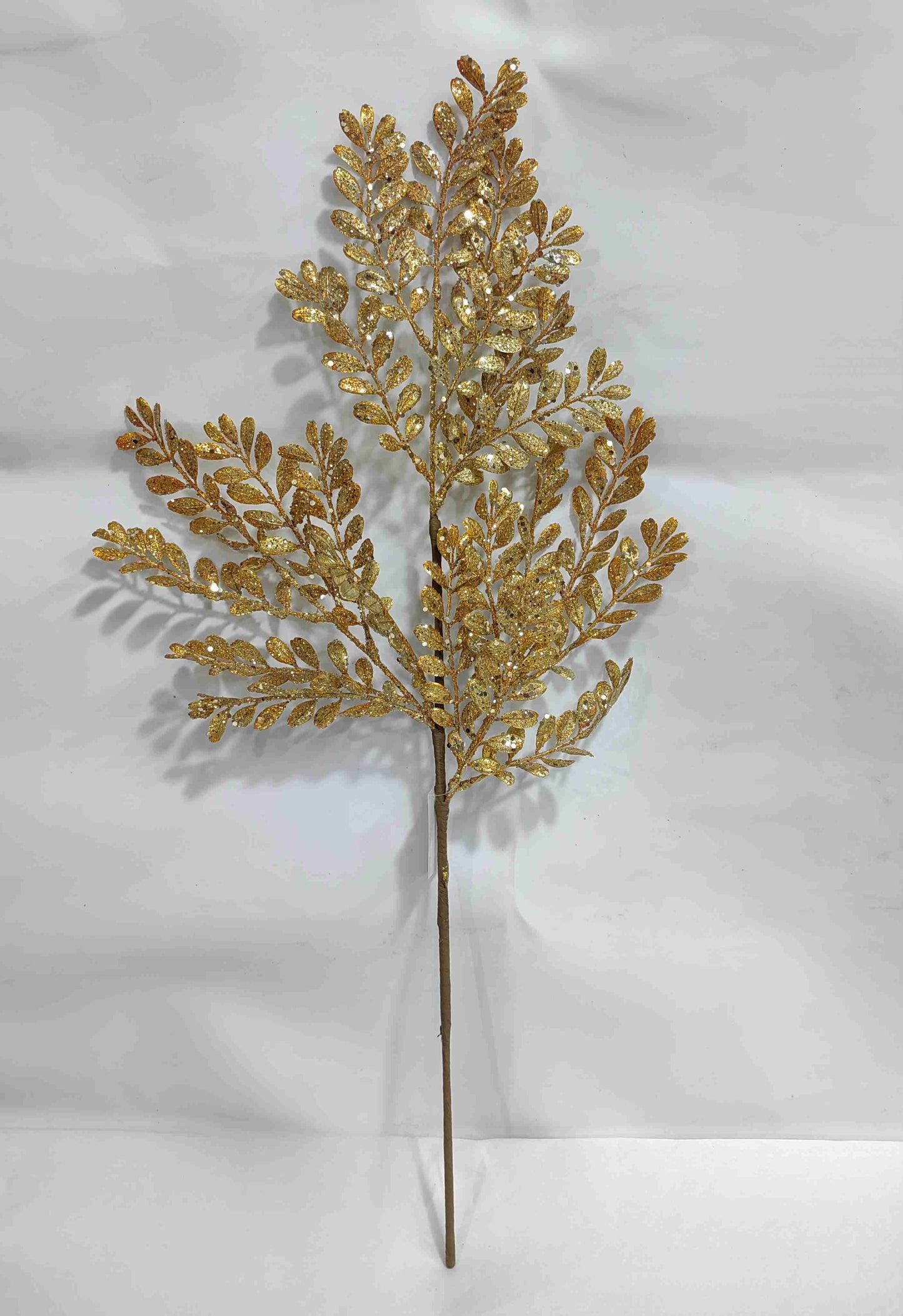 a golden leafy branch with intricate patterns, set against a plain white background.