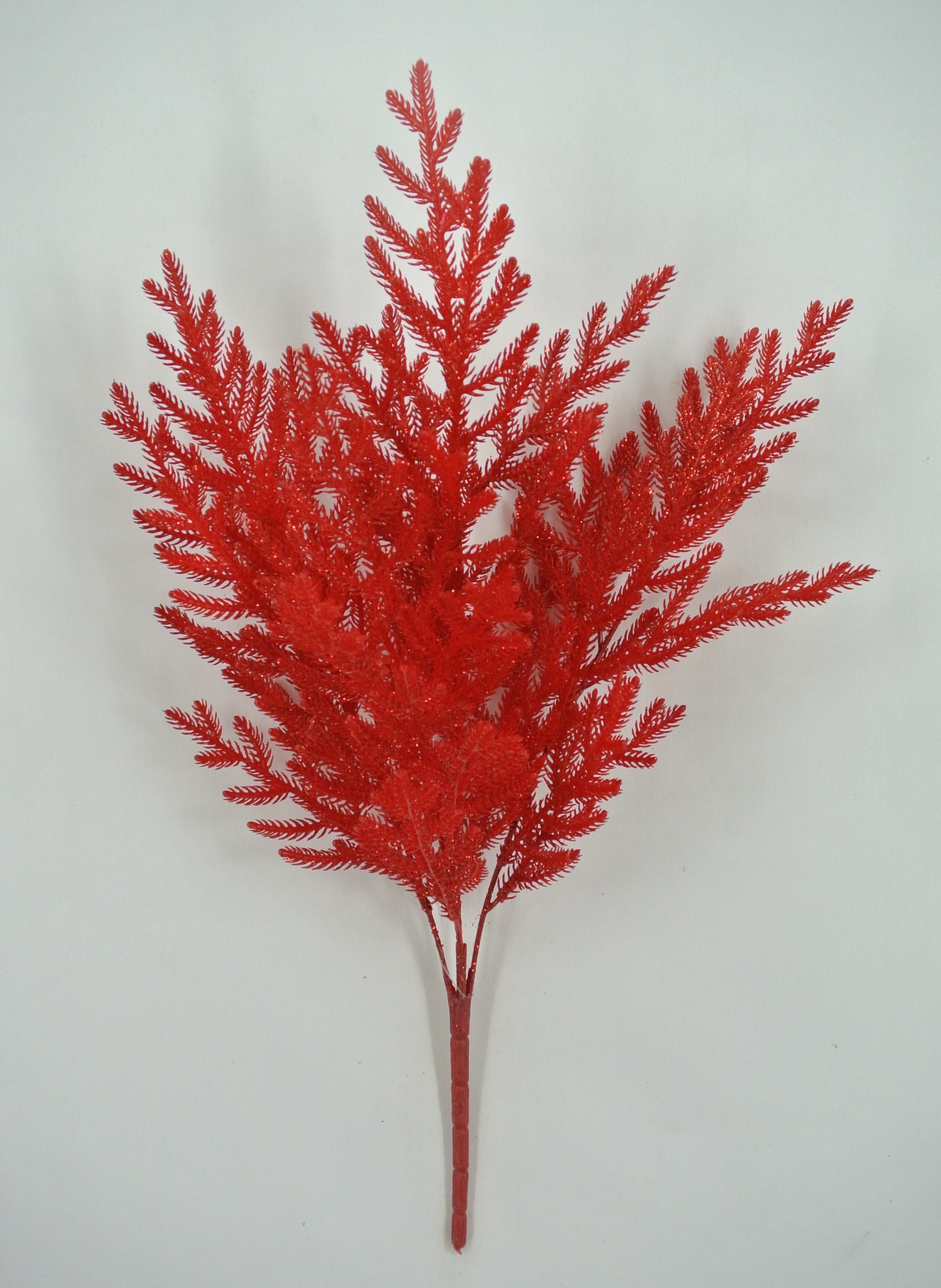 A red artificial plant with multiple branches and leaves, resembling a small tree or plant.