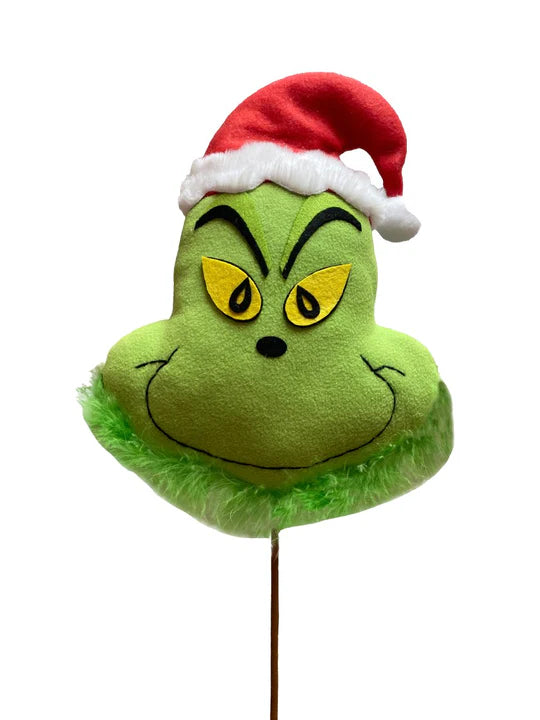 a green grin face with a santa hat on top of a stick