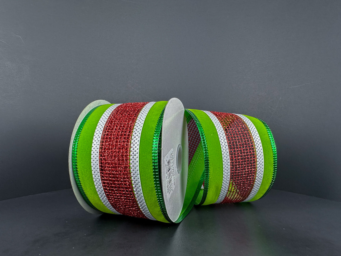 a spool of green and red ribbon on a table