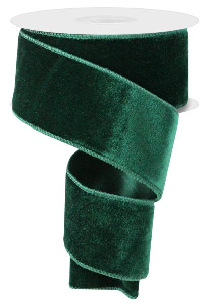 a roll of green velvet ribbon on a white background