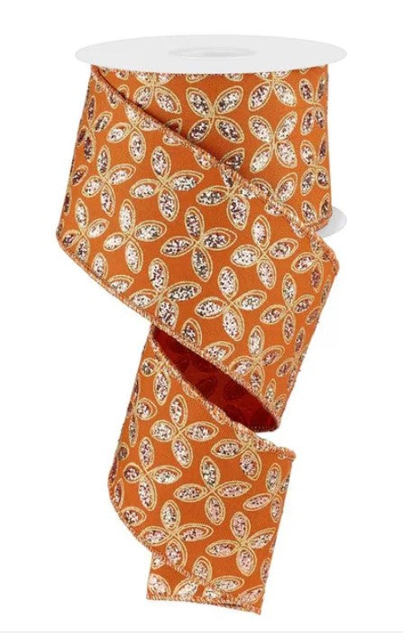 a roll of orange and gold floral patterned ribbon.