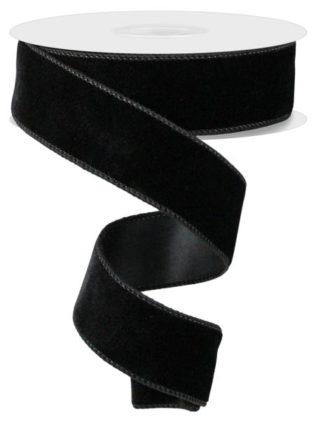 a roll of black velvet ribbon on a white background