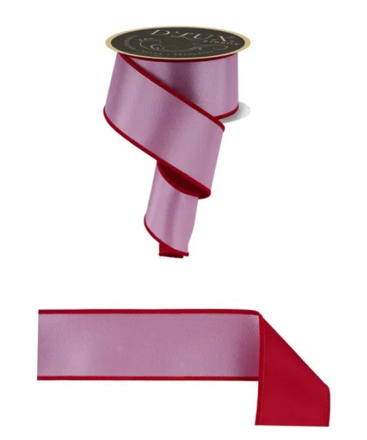 a pink and red ribbon with a black label on top of it.
