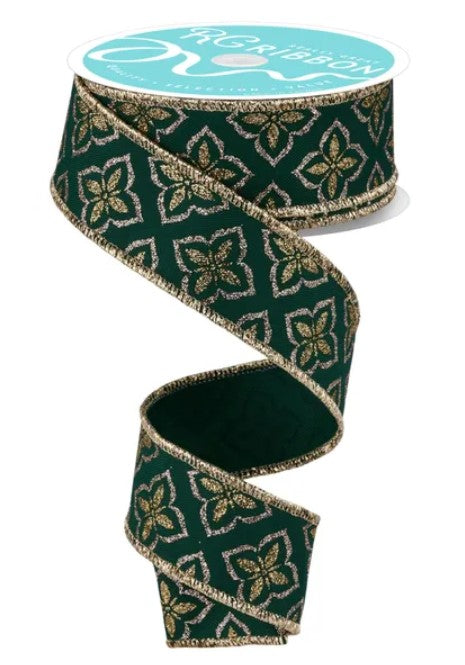 A roll of green and gold floral patterned ribbon with a white label on top.