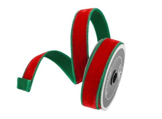 A spool of red and green velvet ribbon is shown against a white background.