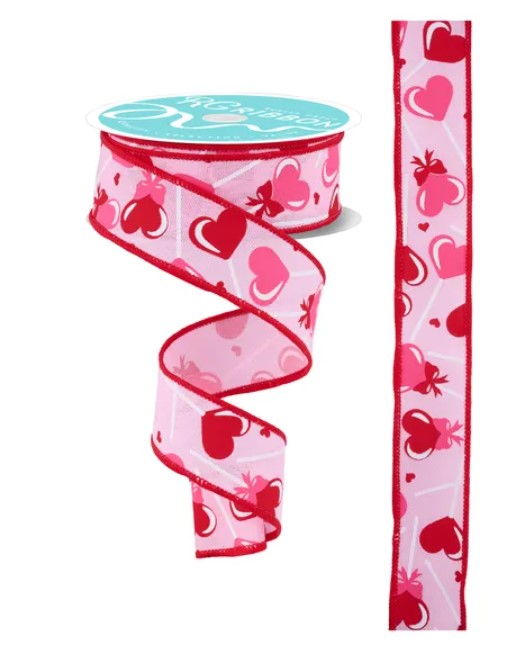 a pink ribbon with a heart pattern, and it is attached to a spool of ribbon.