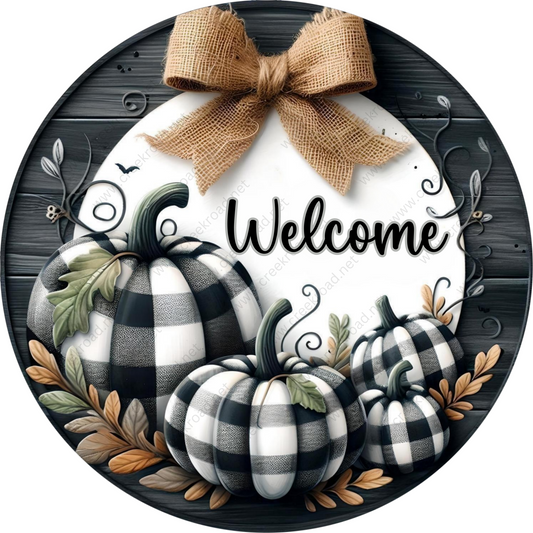 a welcome sign with black and white pumpkins