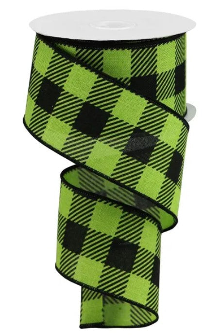 A green and black plaid ribbon is shown, with the ribbon winding around a white object.