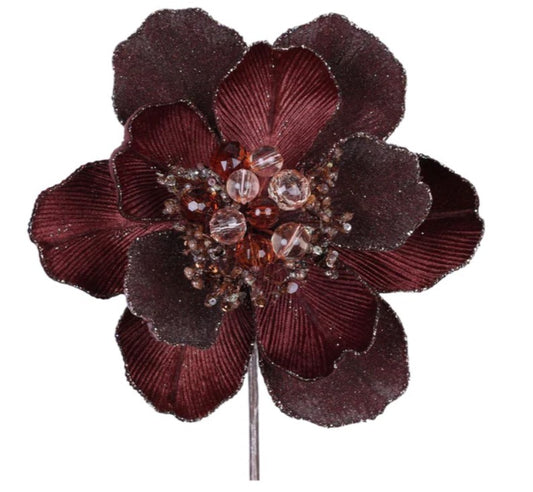 A close-up image of a burgundy-colored flower with a central arrangement of small, clear beads and a metallic stem.