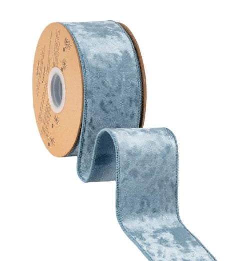 A roll of blue velvet ribbon with a white center is shown against a white background.