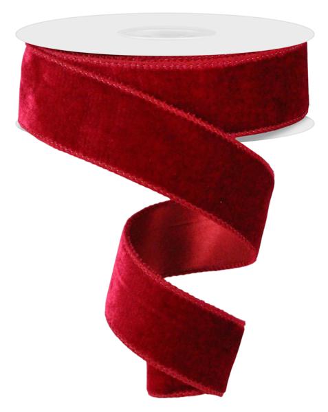 a roll of red velvet ribbon on a white background