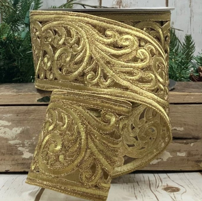 a decorative gold ribbon with an intricate floral pattern, placed on a wooden surface.