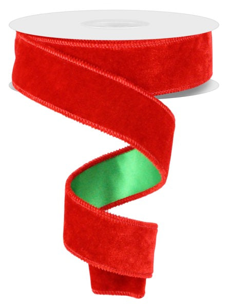 a roll of red velvet ribbon on a white background