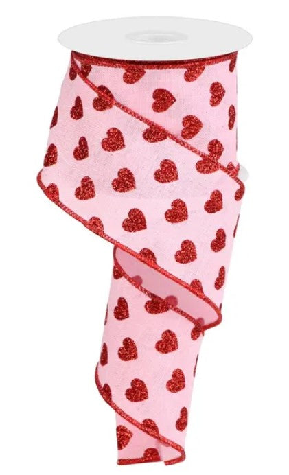 A pink ribbon with a repeating pattern of red hearts on it.