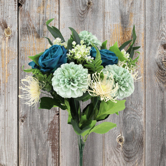 A bouquet of blue roses and green dahlias is displayed against a weathered wooden background.