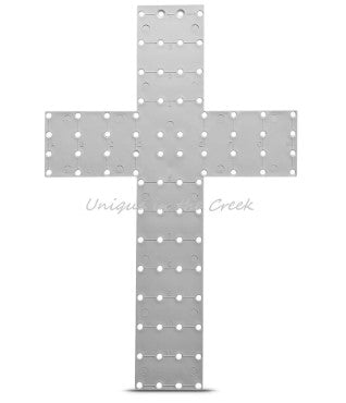 a large, white cross-shaped object with numerous small circular holes arranged in a grid-like pattern.