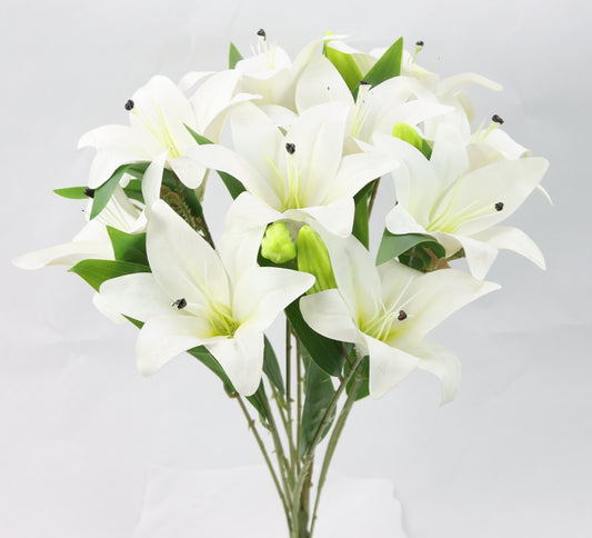 A bouquet of white lilies with green leaves, arranged in a vase against a plain white background.