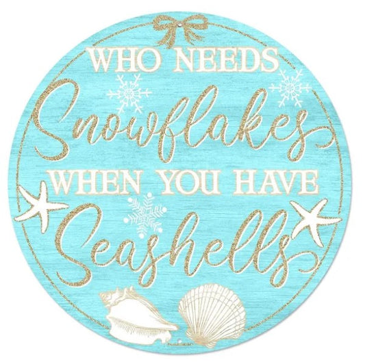 The image is a circular sign with a blue background and gold text that reads "Who needs snowflakes when you have seashells".