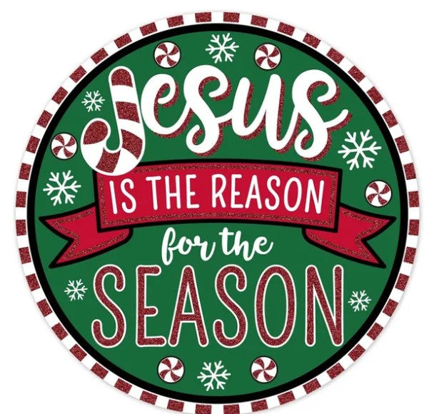 A circular Christmas-themed sign with the text "JESUS IS THE REASON FOR THE SEASON" written in a decorative font.