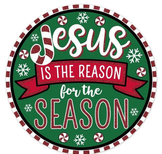 A circular Christmas-themed sign with the text "JESUS IS THE REASON FOR THE SEASON" written in a decorative font.