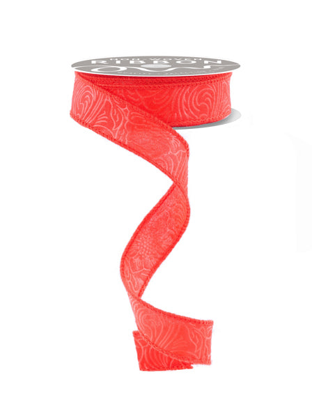 A red ribbon with a floral pattern is shown, coiled and hanging against a white background.