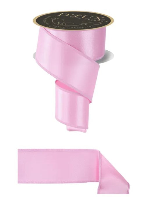 a pink satin ribbon with a black label, and a smaller pink satin ribbon below it.