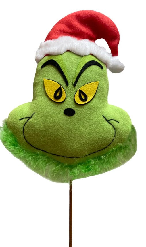 a green grin face with a santa hat on top of a stick