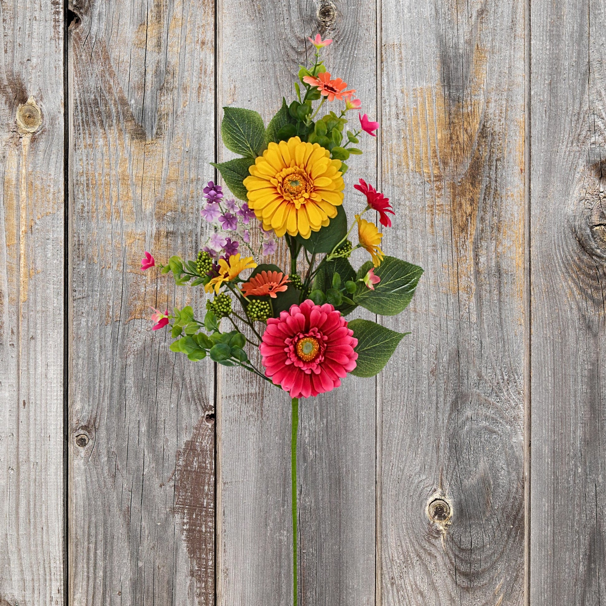 A vibrant bouquet of colorful flowers, including yellow and red blooms, is displayed against a weathered wooden background.