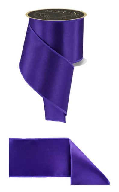 a roll of purple satin ribbon with a gold label.