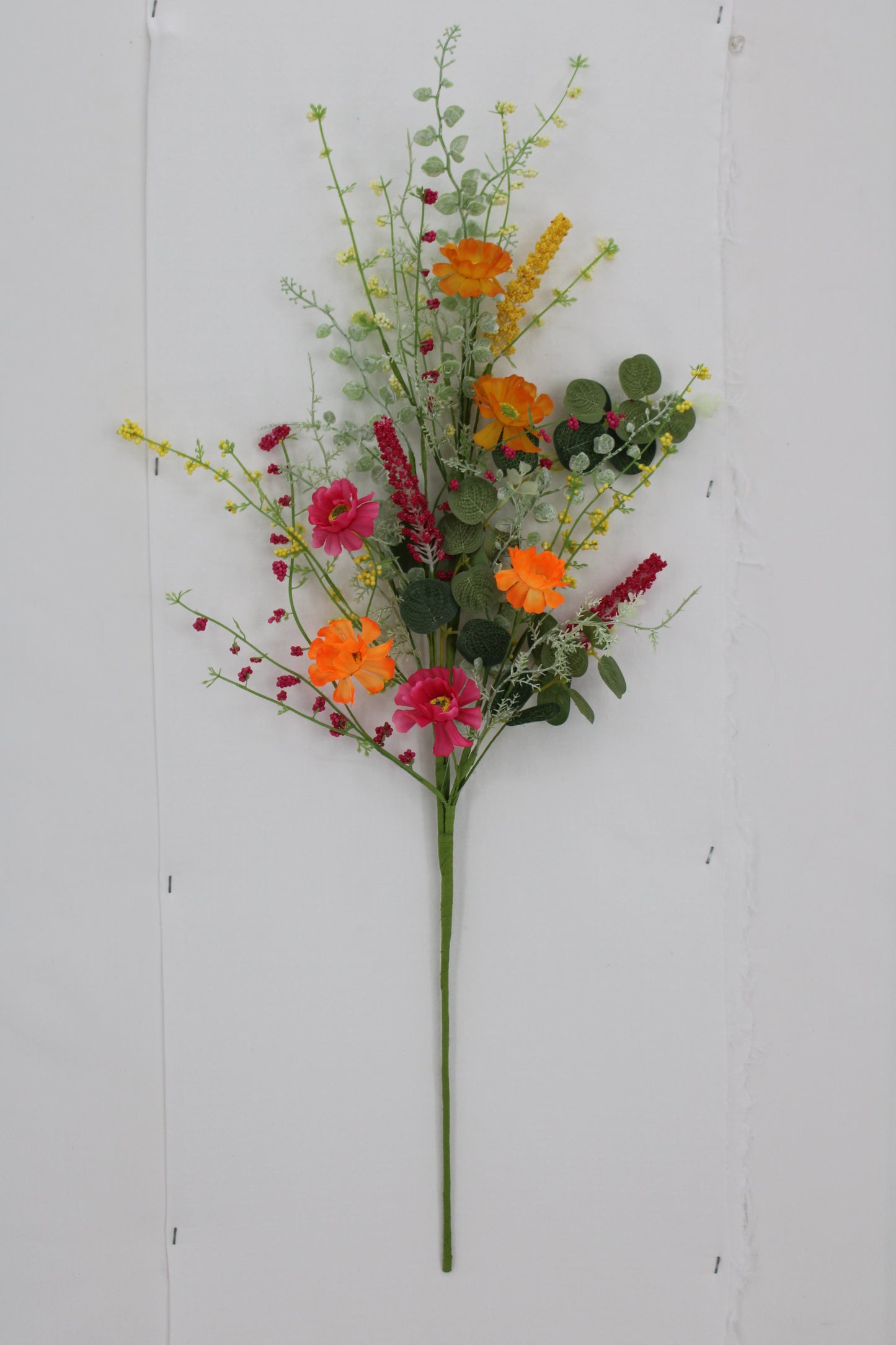 A bouquet of colorful flowers, including red, orange, and yellow blooms, is displayed against a white background.
