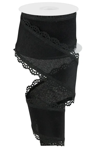 A black ribbon with a scalloped edge and lace-like patterns, sitting on a white spool.