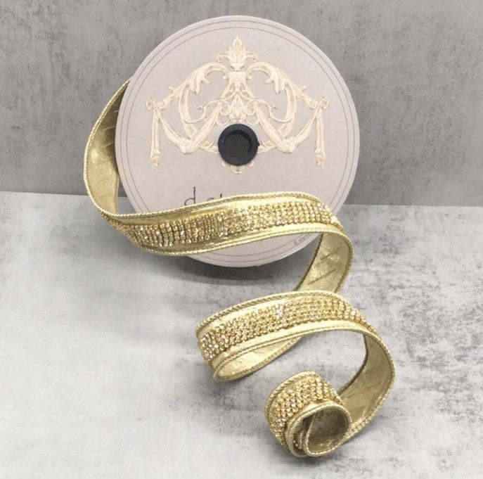 a gold-colored ribbon with a decorative pattern, placed on a gray surface.